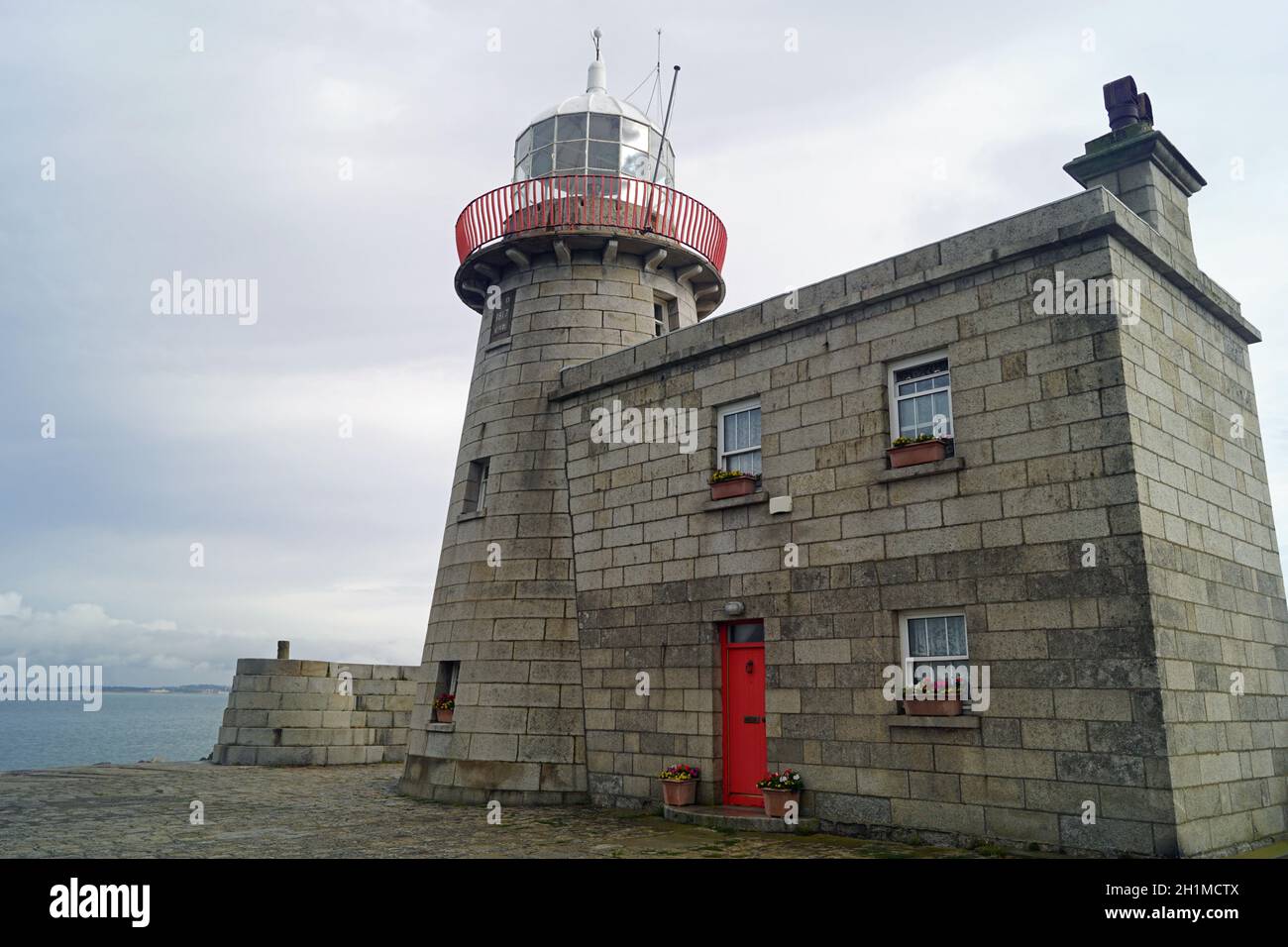 The lighthouse guards the entrance to the port of Howth Stock Photo Alamy