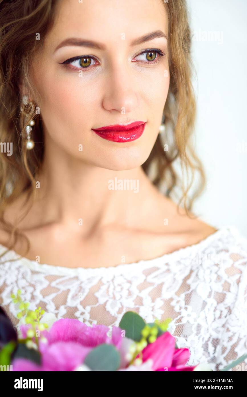 joyful girl bride in a white knitted dress posing with a bouquet of ...