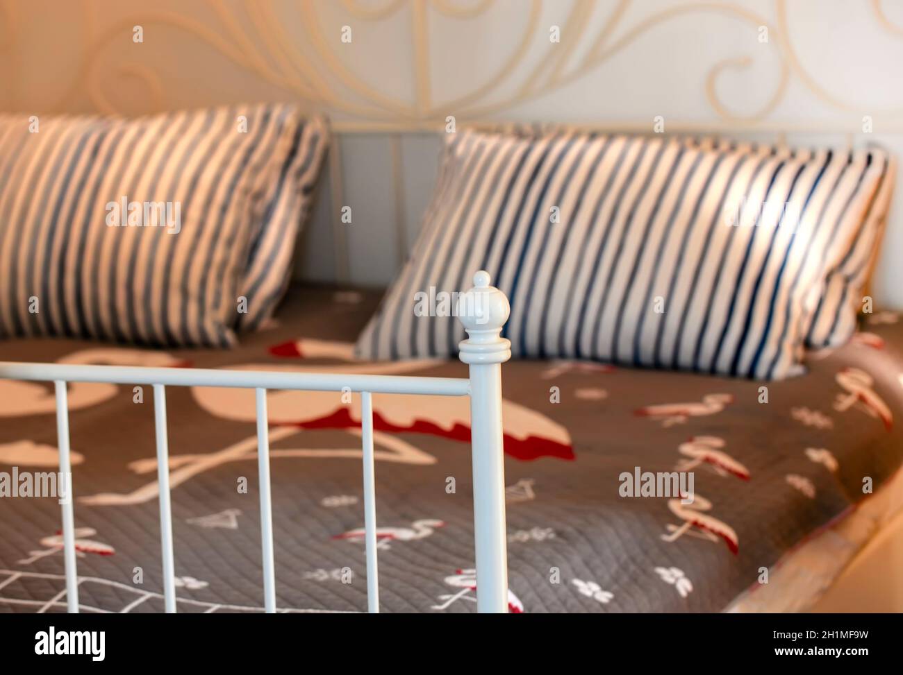 The stylish bedroom interior design with patterned pillows on bed. Selective focus Stock Photo