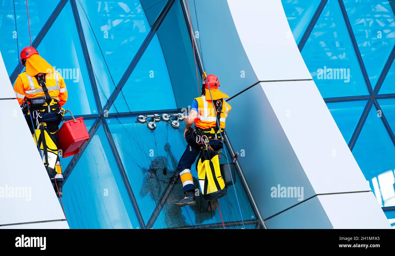 The window cleaner working on a glass facade modern skyscraper Stock Photo