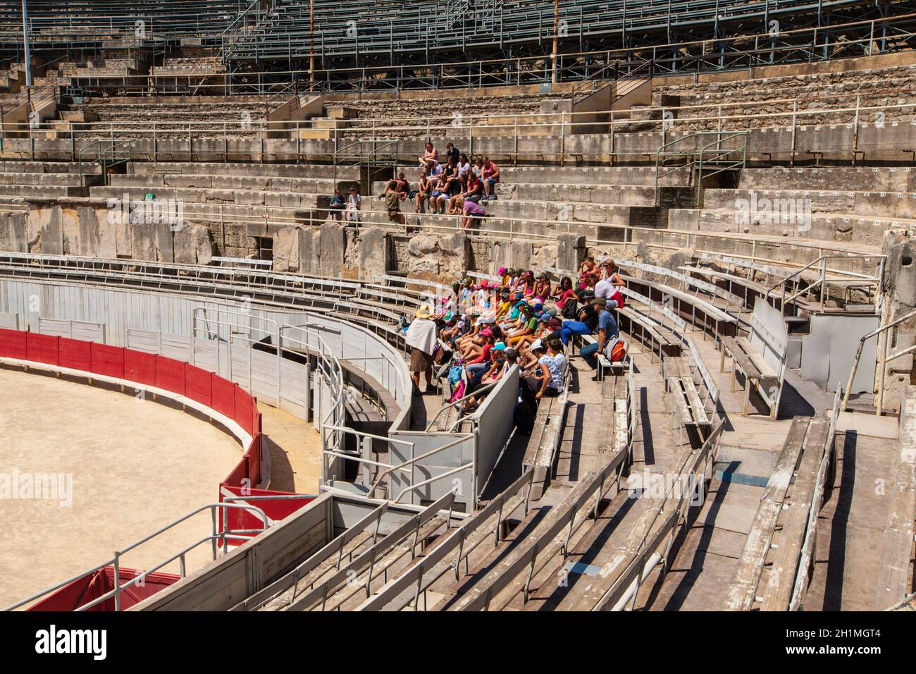 Arles, France - JUNE 19 - 2018: A group of tourists resting on the steps of the ancient amphitheater. Stock Photo