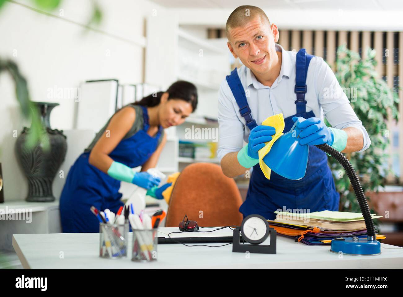 Workers cleaning desk in modern office Stock Photo Alamy