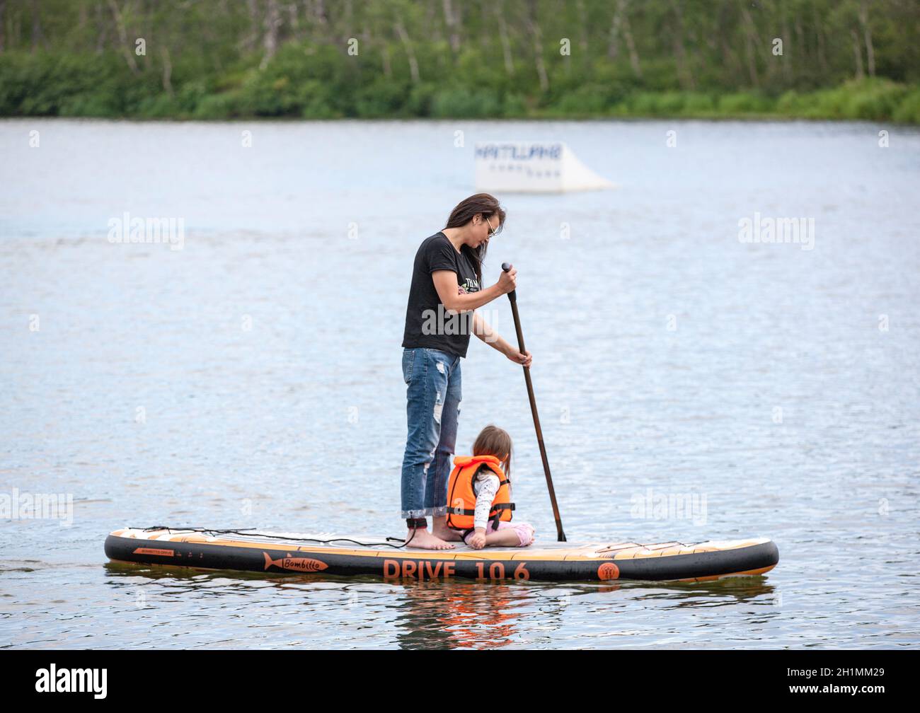 kamchatka, Russia 02 August 2019: Men and women with her baby stand up paddle boarding (sup) on lake in recreation center 'Blue Loguna' in Kamchatka Stock Photo