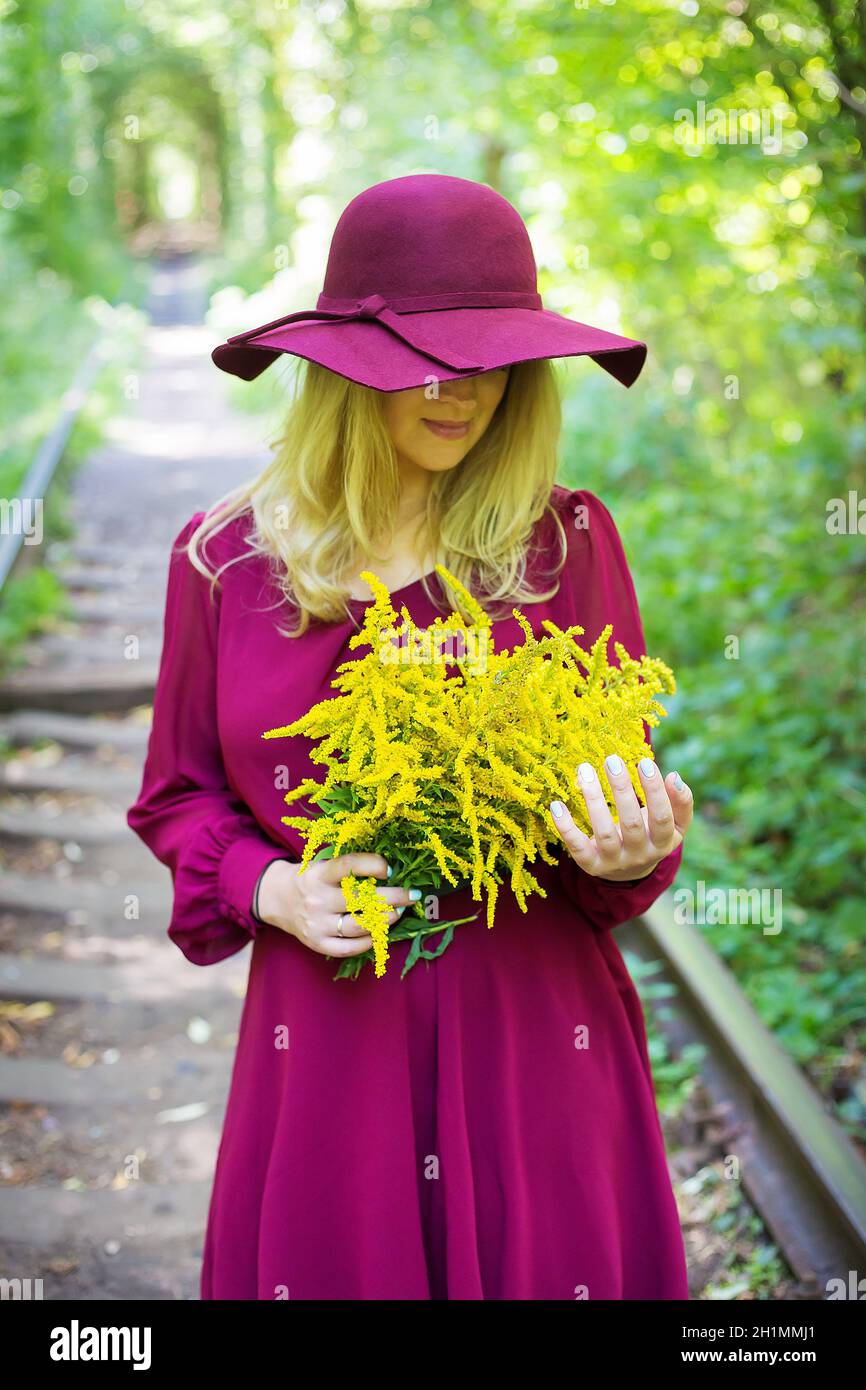 girl in a hat with a bouquet of yellow flowers Stock Photo - Alamy