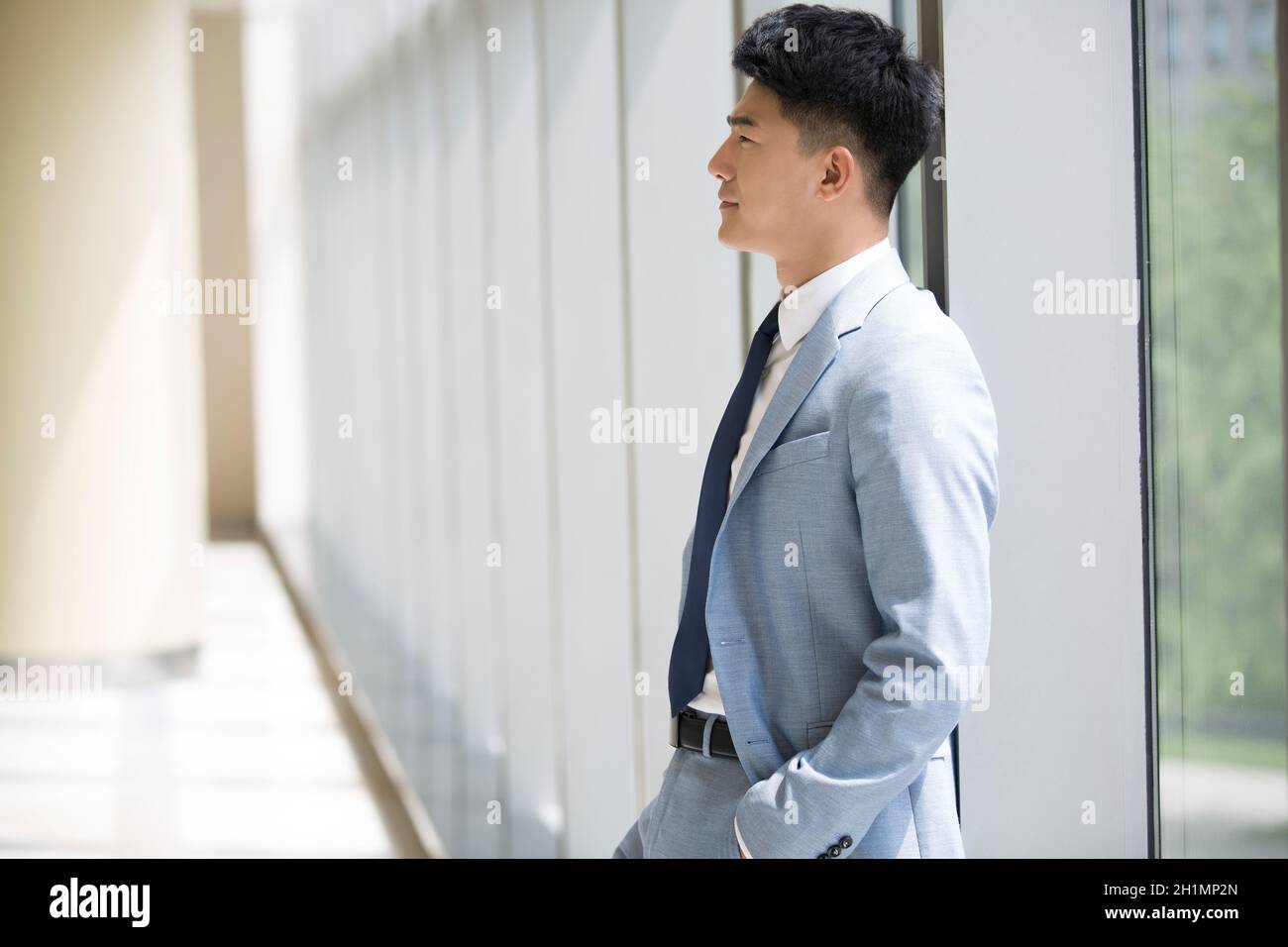 Businessman standing by the window and thinking Stock Photo