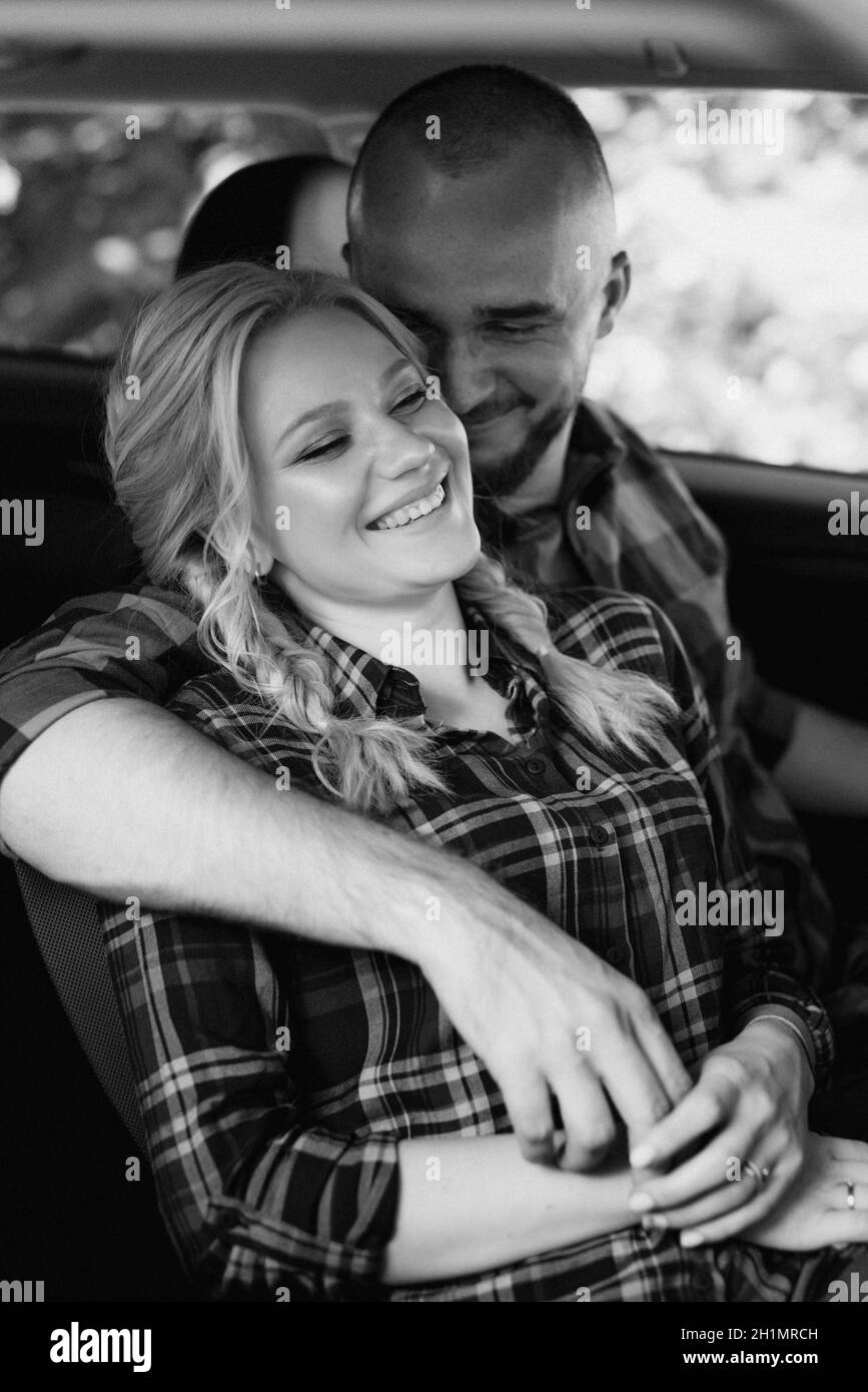 traveling by car of a young couple of a guy and a girl in plaid shirts Stock Photo