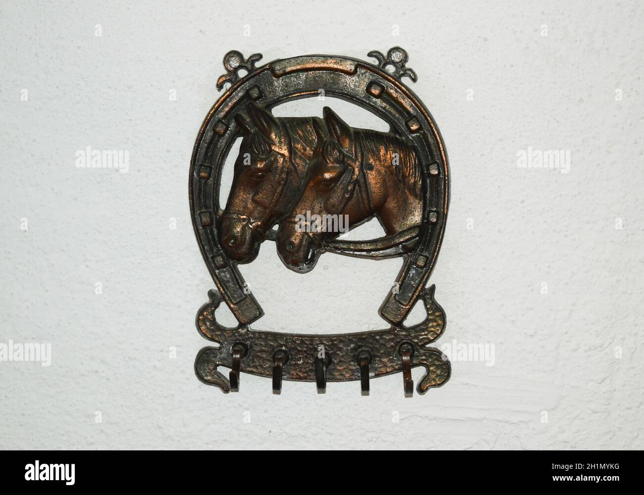 Clothes hanger decorated with the image of a horseshoe and the heads of horses. Stock Photo
