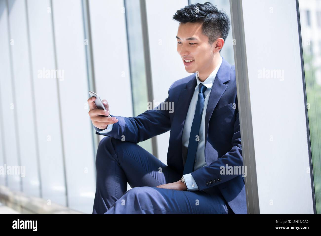 Businessman staring at his mobile phone Stock Photo