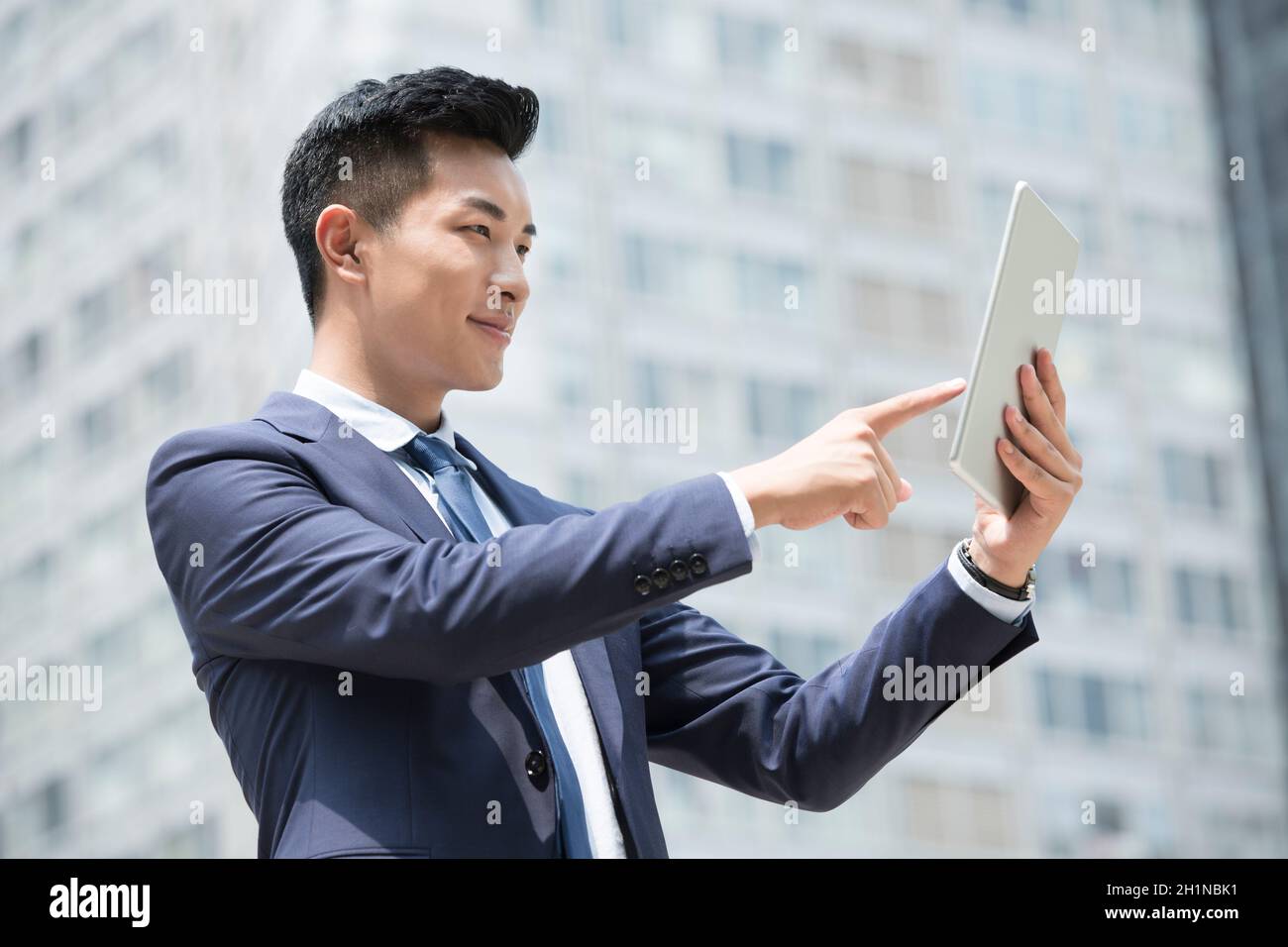 Cheerful businessman tablet standing hi-res stock photography and ...