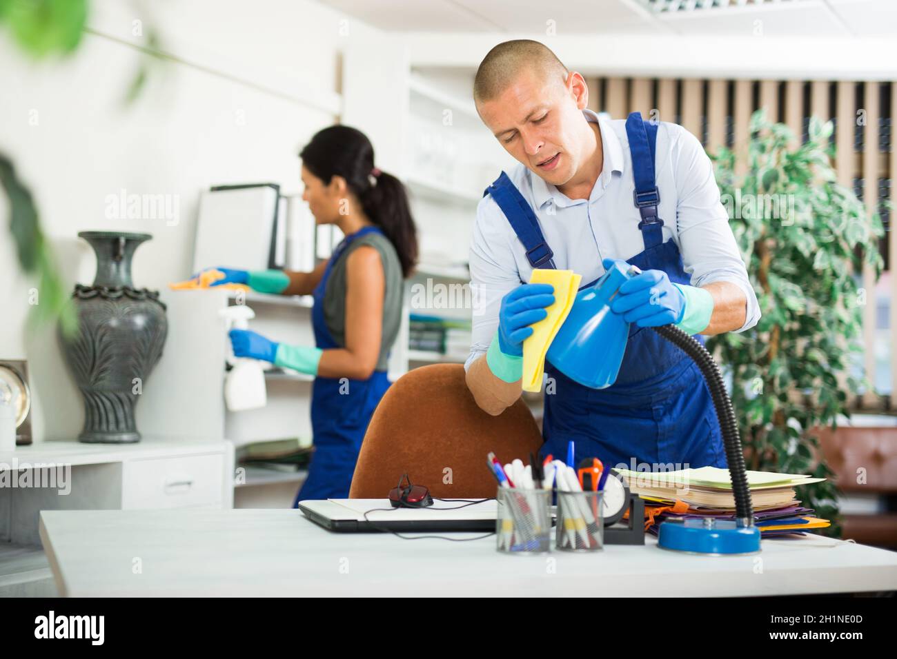 Workers cleaning desk in modern office Stock Photo - Alamy