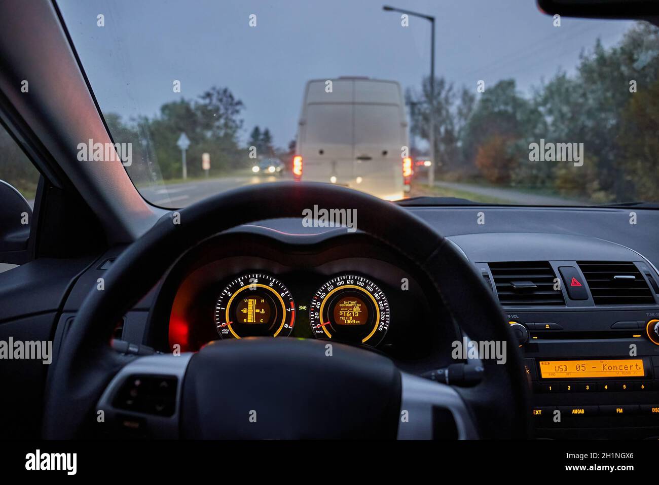 Driving a a car, stoping at a stop light in evening dim light Stock