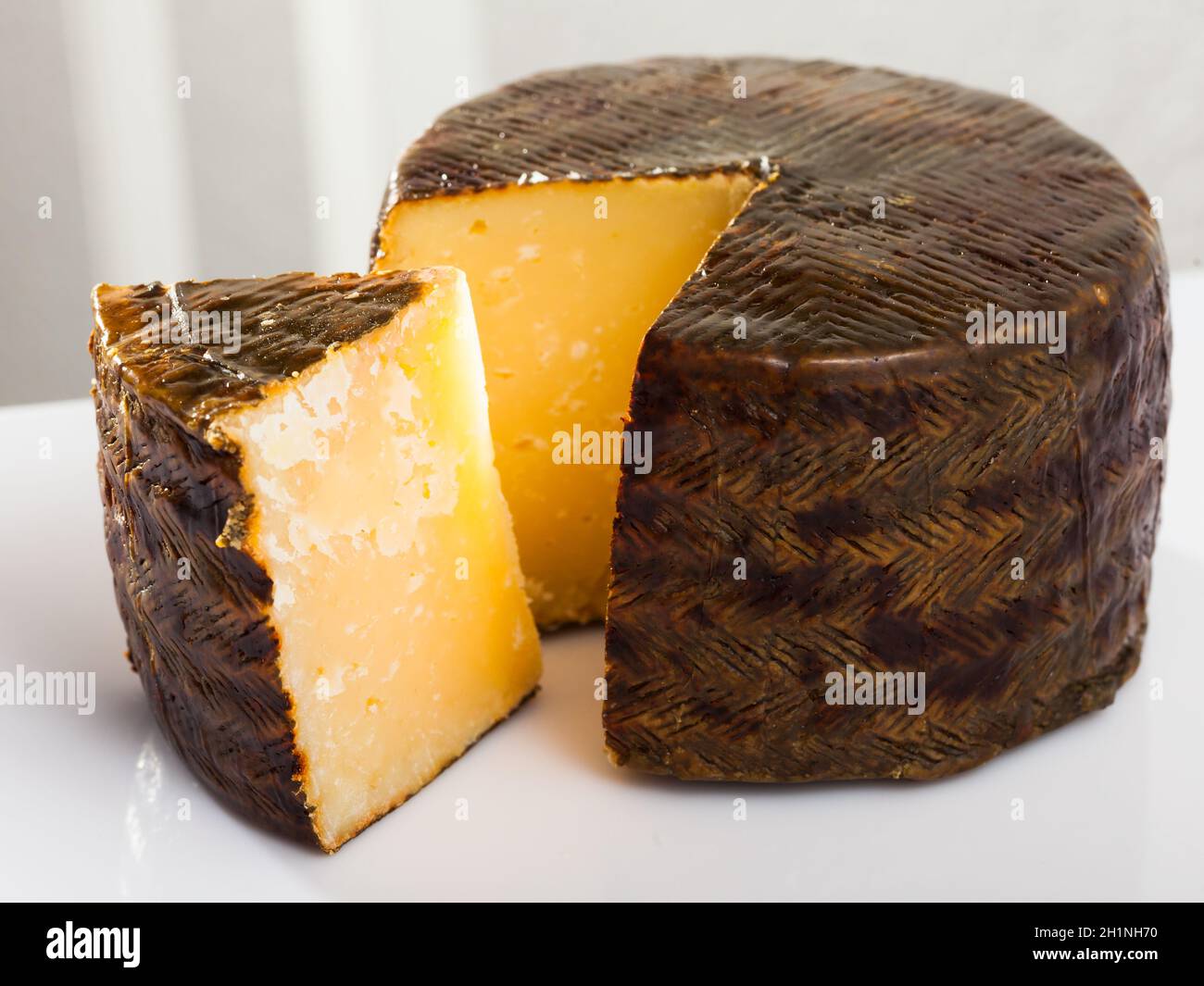 Wheel of cheese Manchego with cut slice Stock Photo Alamy