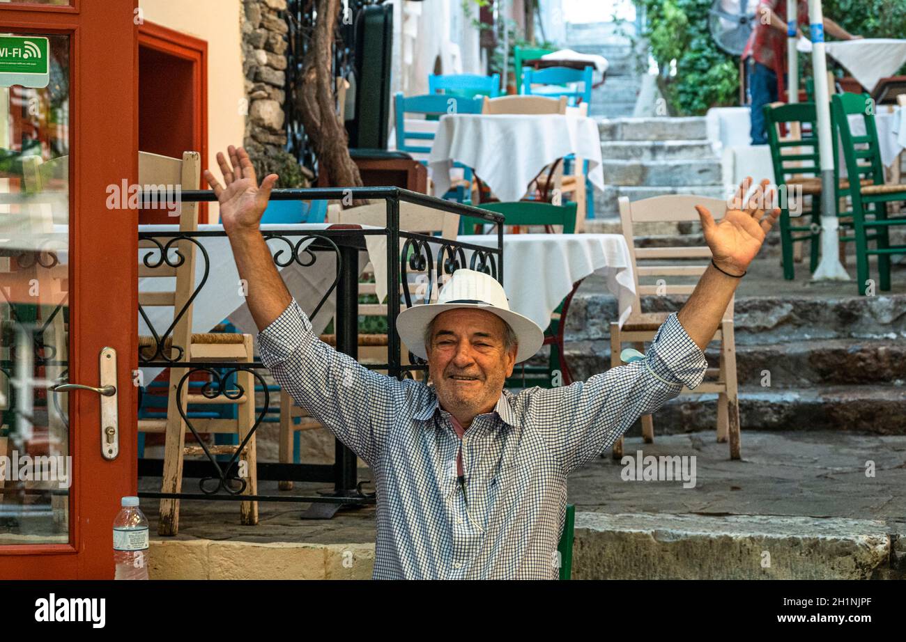 restuarant owner welcoming people to his cafe on teh Yiasemi public stairs cafe Stock Photo