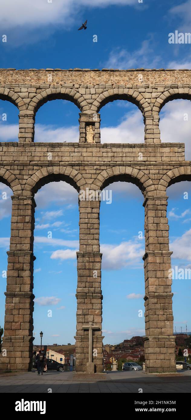 Bird flying with wings open above Segovia Viaduct with religious symbol, Spain Stock Photo