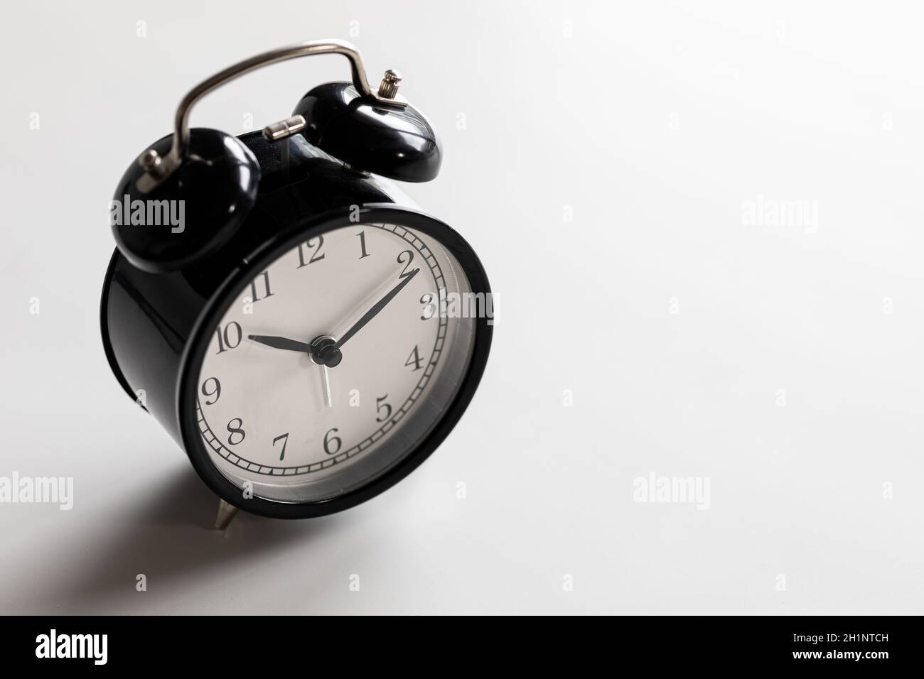 Black and white vintage classic alarm clock at ten o'clock and ten
