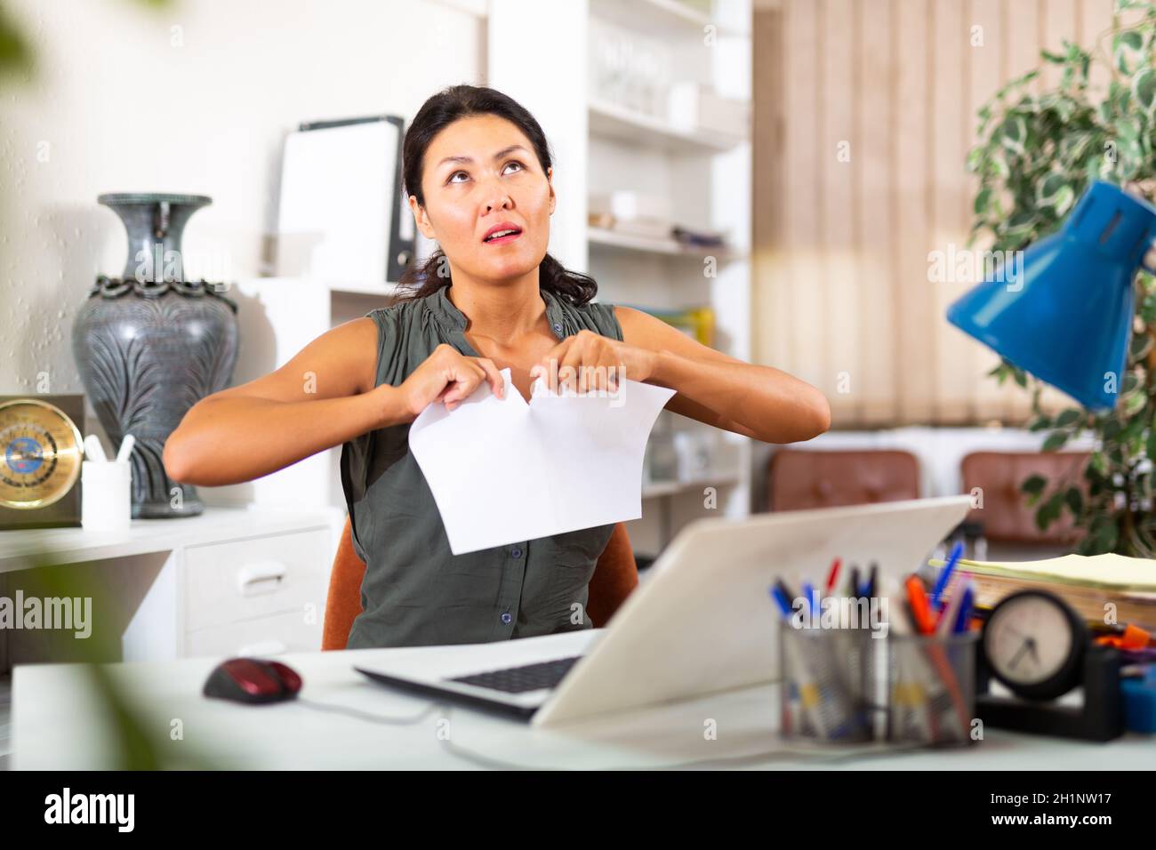 Desperate aggressive business woman ripping paper documents in office Stock Photo