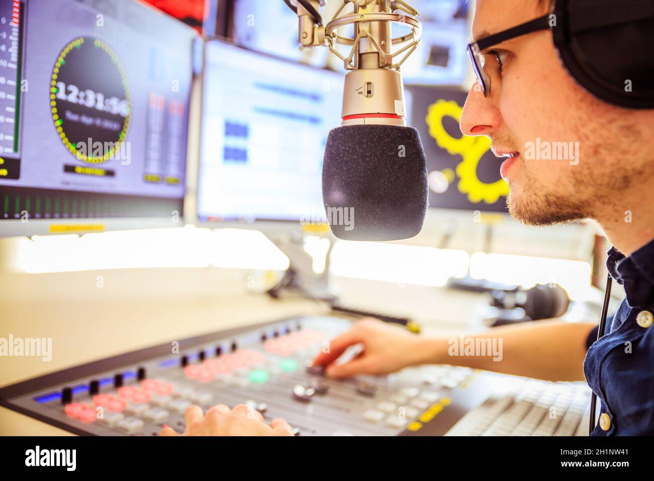 Young man in the broadcasting studio, radio, talking into the