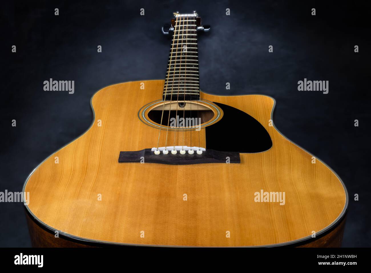 acoustic guitar with yellow deck and black pickguard on isolated black background Stock Photo