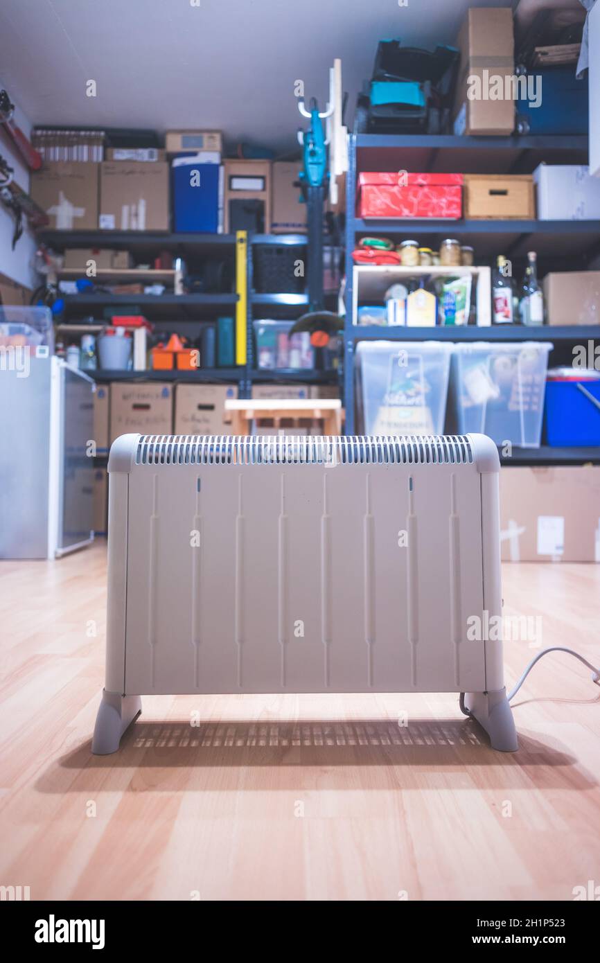 Electric heater, heating the basement. Blurry shelfs in the background Stock Photo