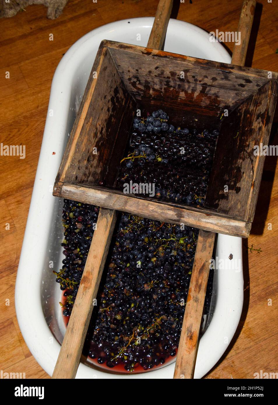 Manual mechanism for crushing grapes. Crush the grapes into juice and