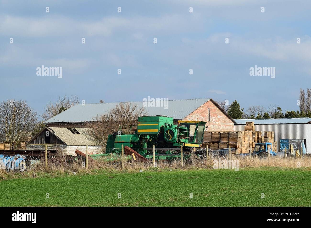 Old tractor and harvester in a brick shed. Store the old equipment. Stock Photo