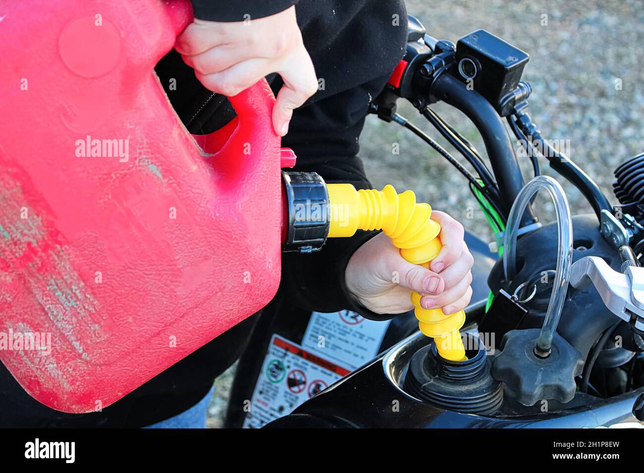Filling a gas tank up on a quad Stock Photo Alamy