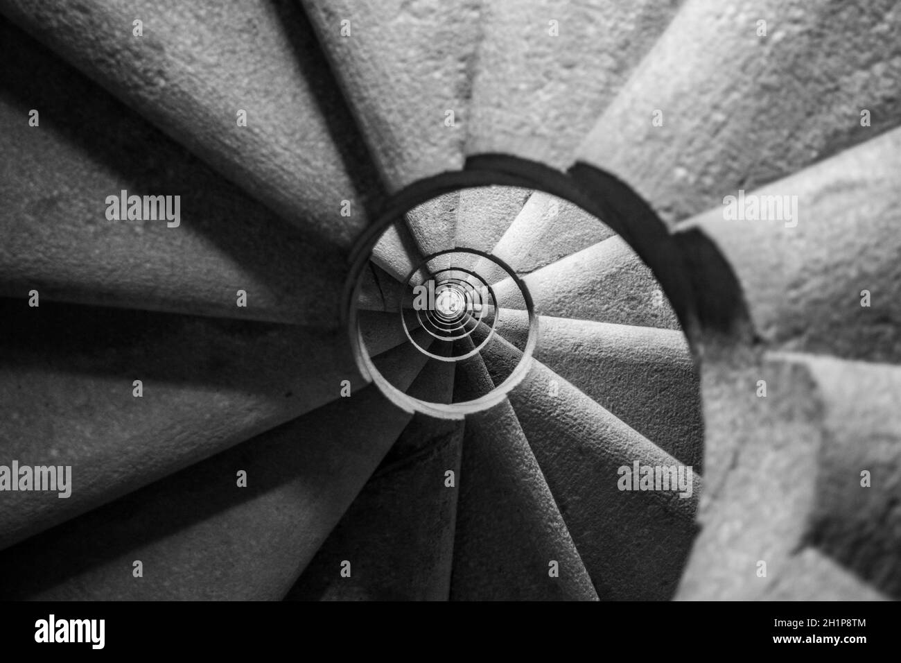 Winding and spiralling concrete staircase in a tower, with infinity point. Black and White edit Stock Photo