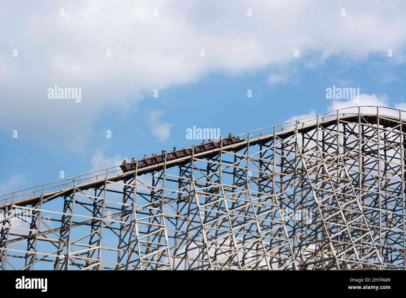 Unrecognizable persons on a roller coaster in an amusement park. Stock Photo