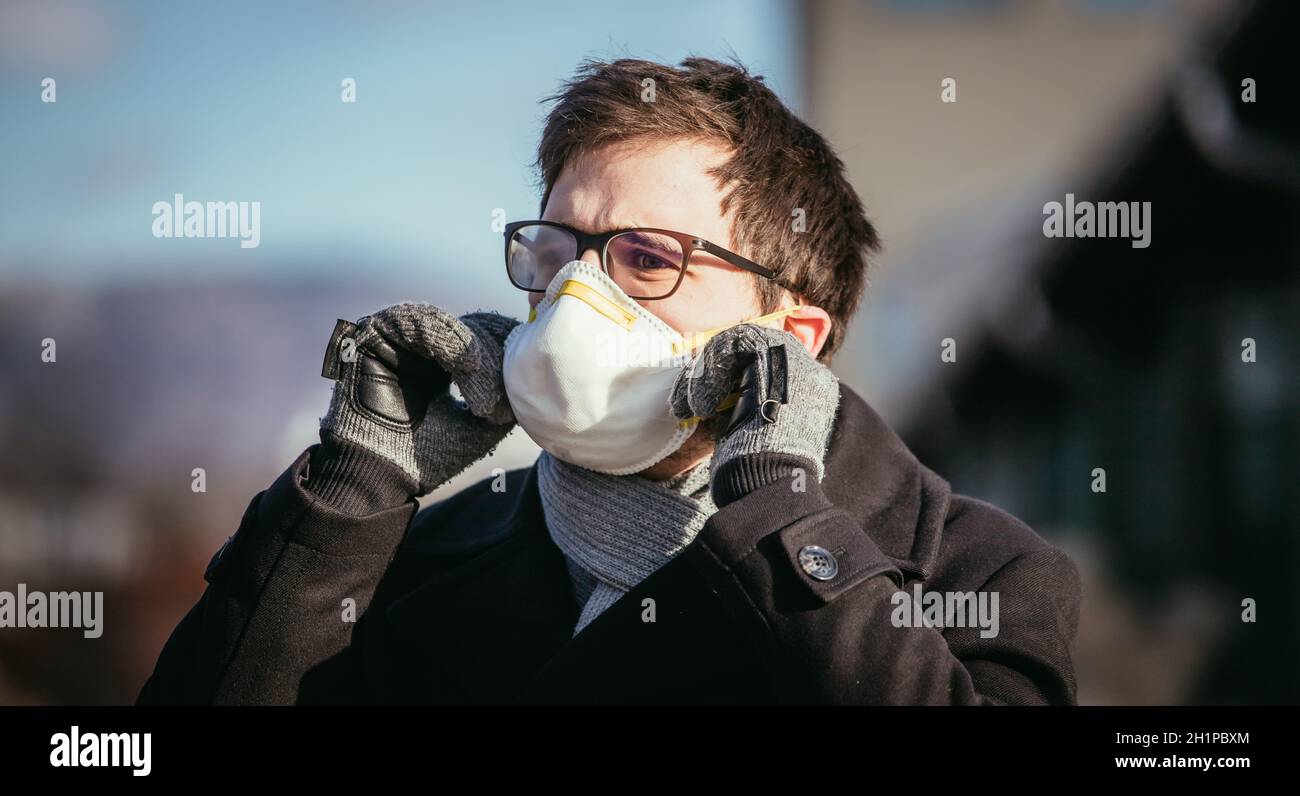 Young man outdoors with a breathing mask. Flue and corona season Stock Photo