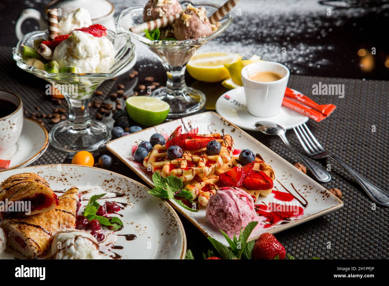 Italian dessert - crispy waffles with ice cream, cream cheese and jam. Pieces of fruit for dessert. Concept - sweet food, obesity problem. Stock Photo