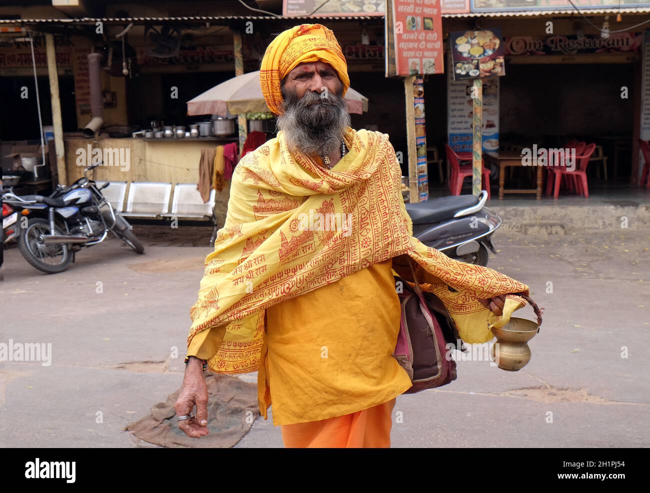 Indian sadhu holy man walking at the bazaar and collect alms in Pushkar, India Stock Photo