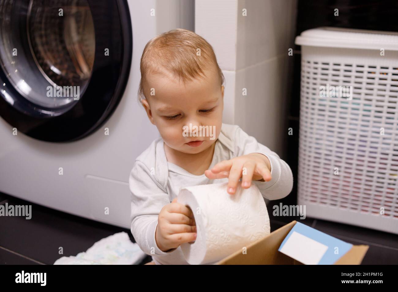 Toddler boy plays with toilet paper Stock Photo Alamy