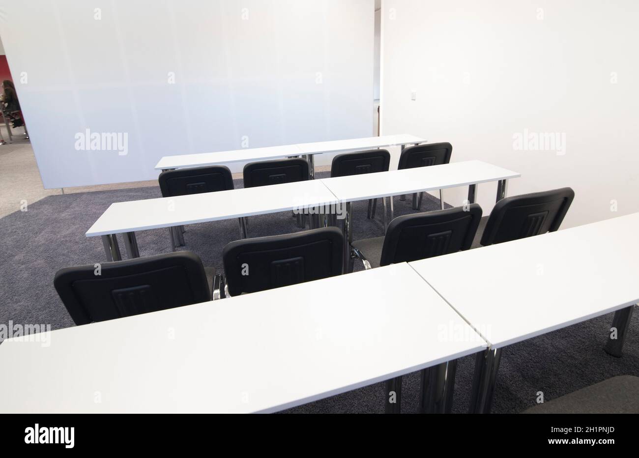 bright seminar room with chairs, desks and a grey carpet Stock Photo