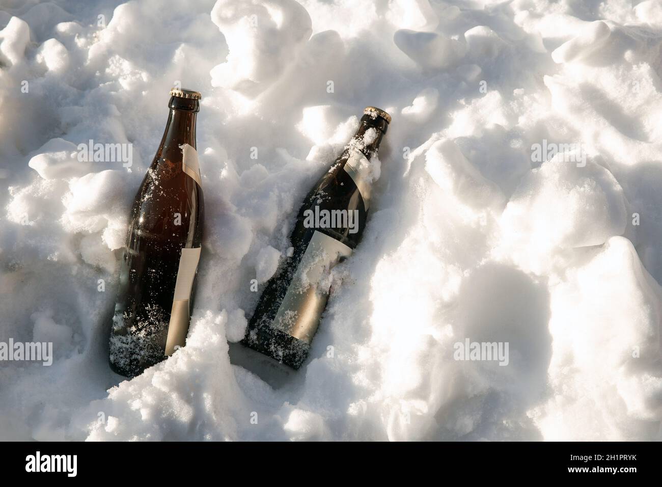 Two ice cold brown beer bottles in fresh white snow in the sun background, Winter,Snow,alcohol,drink concept copy space beauty Stock Photo