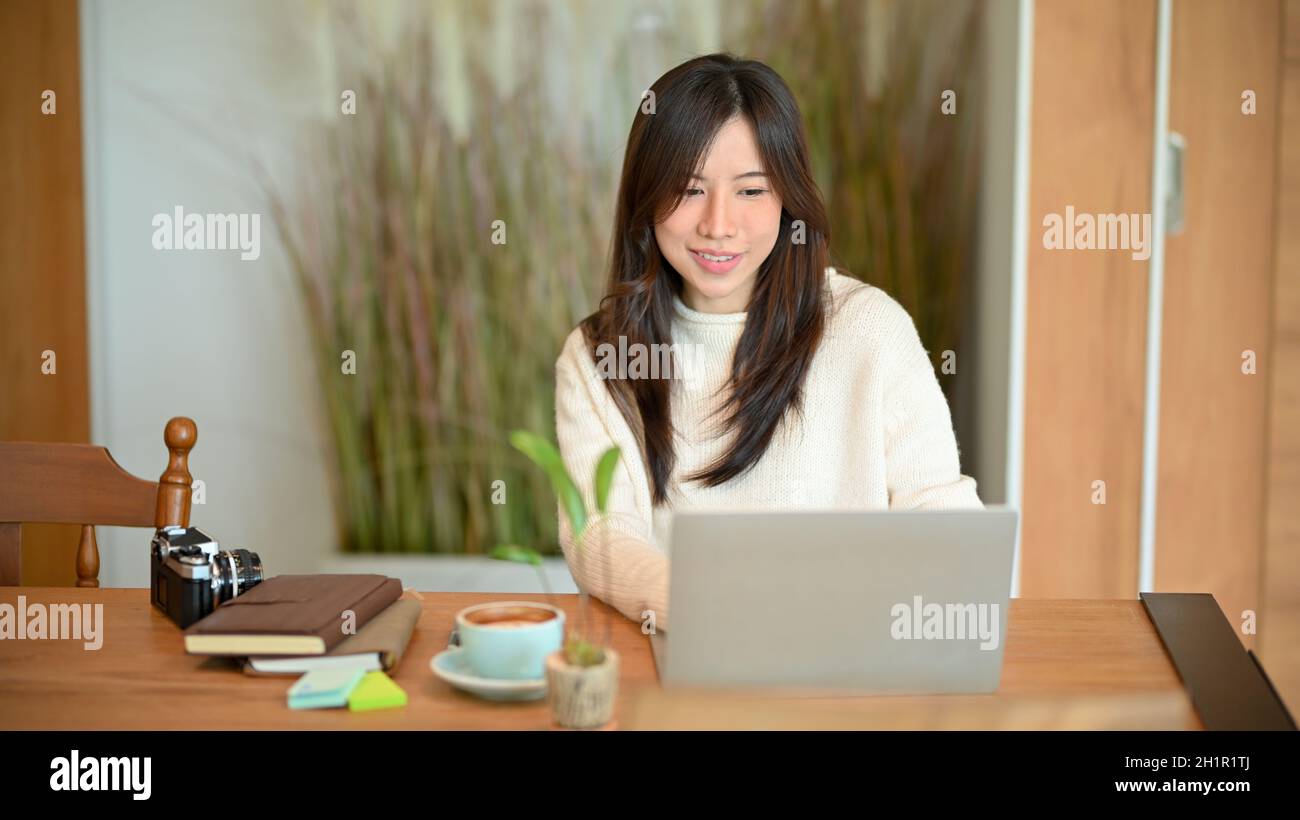 Young asian female photographer or travel blogger working on laptop  computer at minimalist Japanese style coffee shop Stock Photo - Alamy