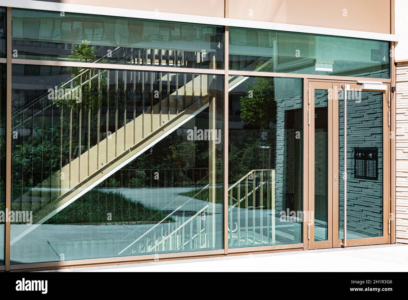 entrance with transparent windows and door, through the transparent door you can see the stairs, sunny day Stock Photo