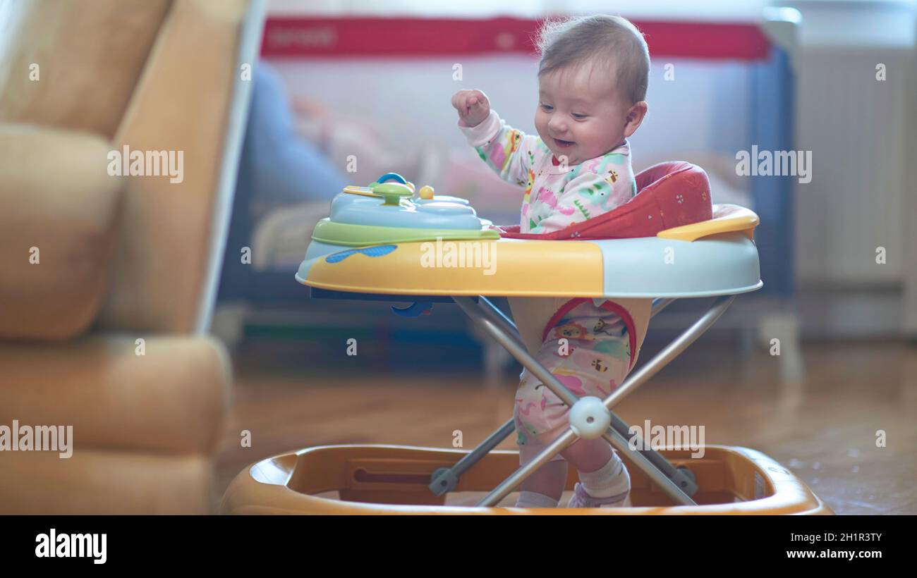 cute little baby learning to walk in walker at home Stock Photo Alamy