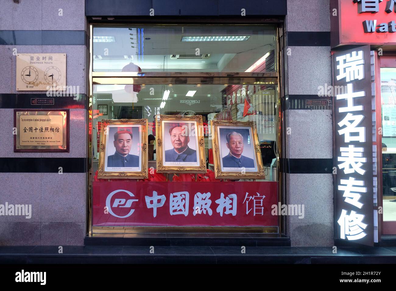 Portraits of three famous Chinese politicians in shop window on famous Wangfujing Street in