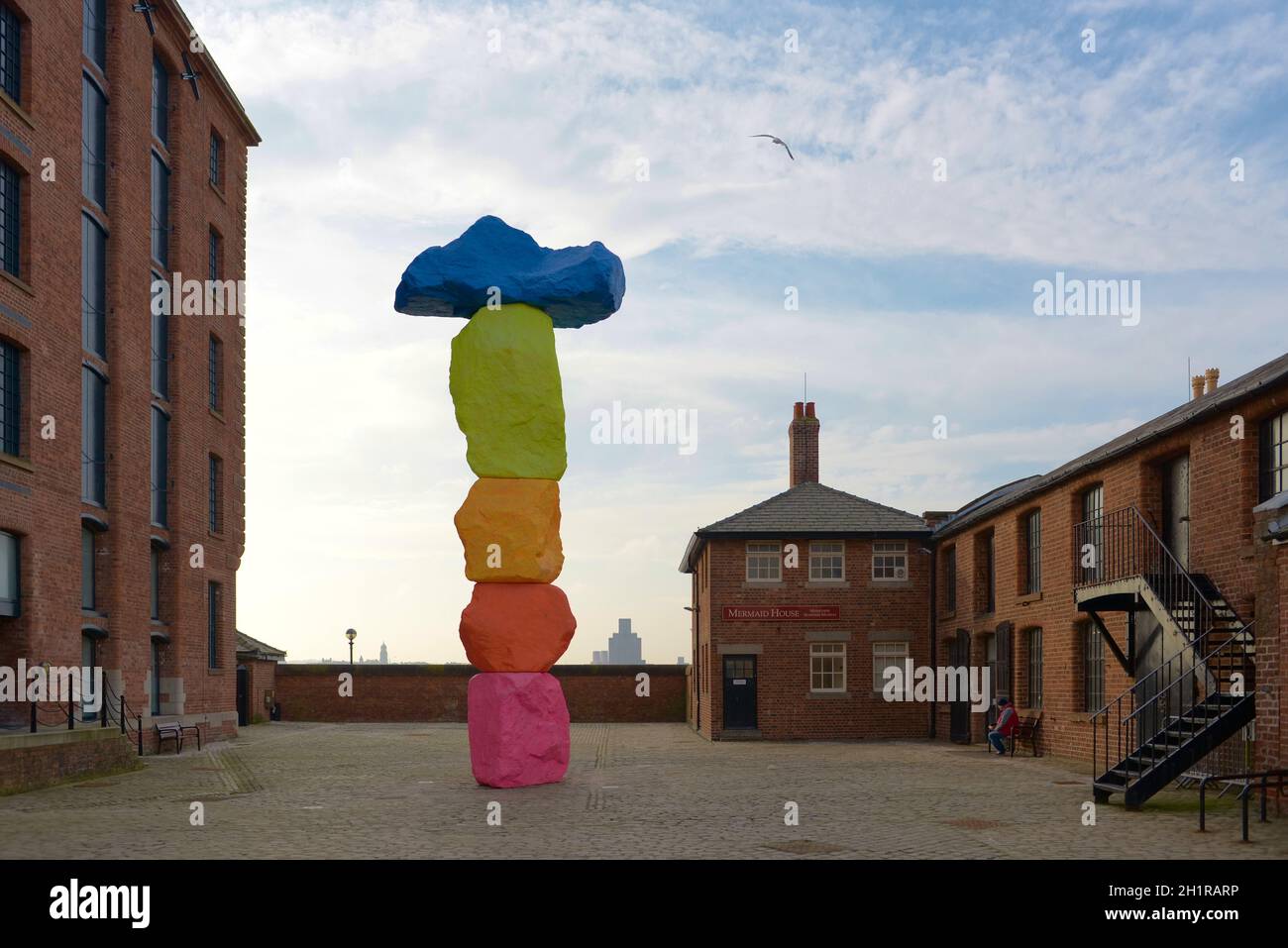 Liverpool, United Kingdom, 2nd February, 2020: Red brick buildings at the royal albert dock surround the liverpool mountain sculpture outside tate Stock Photo