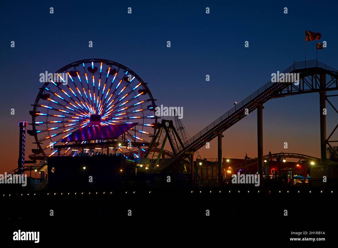 Ferris wheel and roller coaster at dusk, Pacific Park, Santa Monica ...