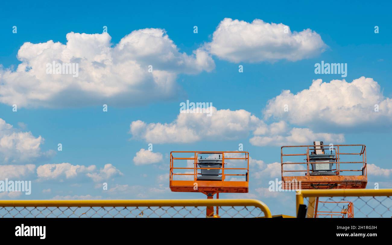 Articulated boom lift. Aerial platform lift. Telescopic boom lift against blue sky. Mobile construction crane for rent and sale. Maintenance and repai Stock Photo