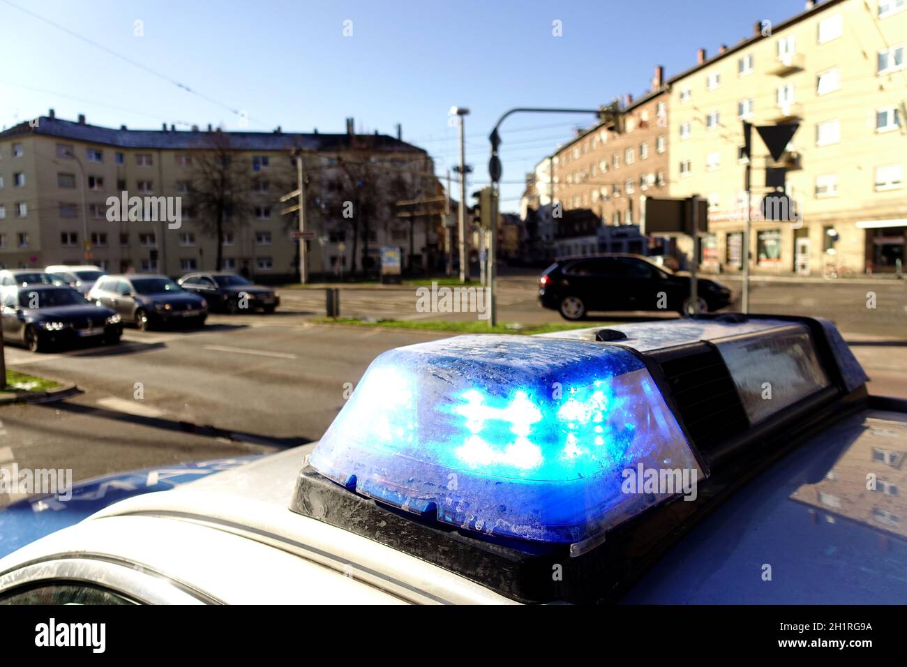 Blue flashing lights on a police car in a town in Germany. Houses, cars