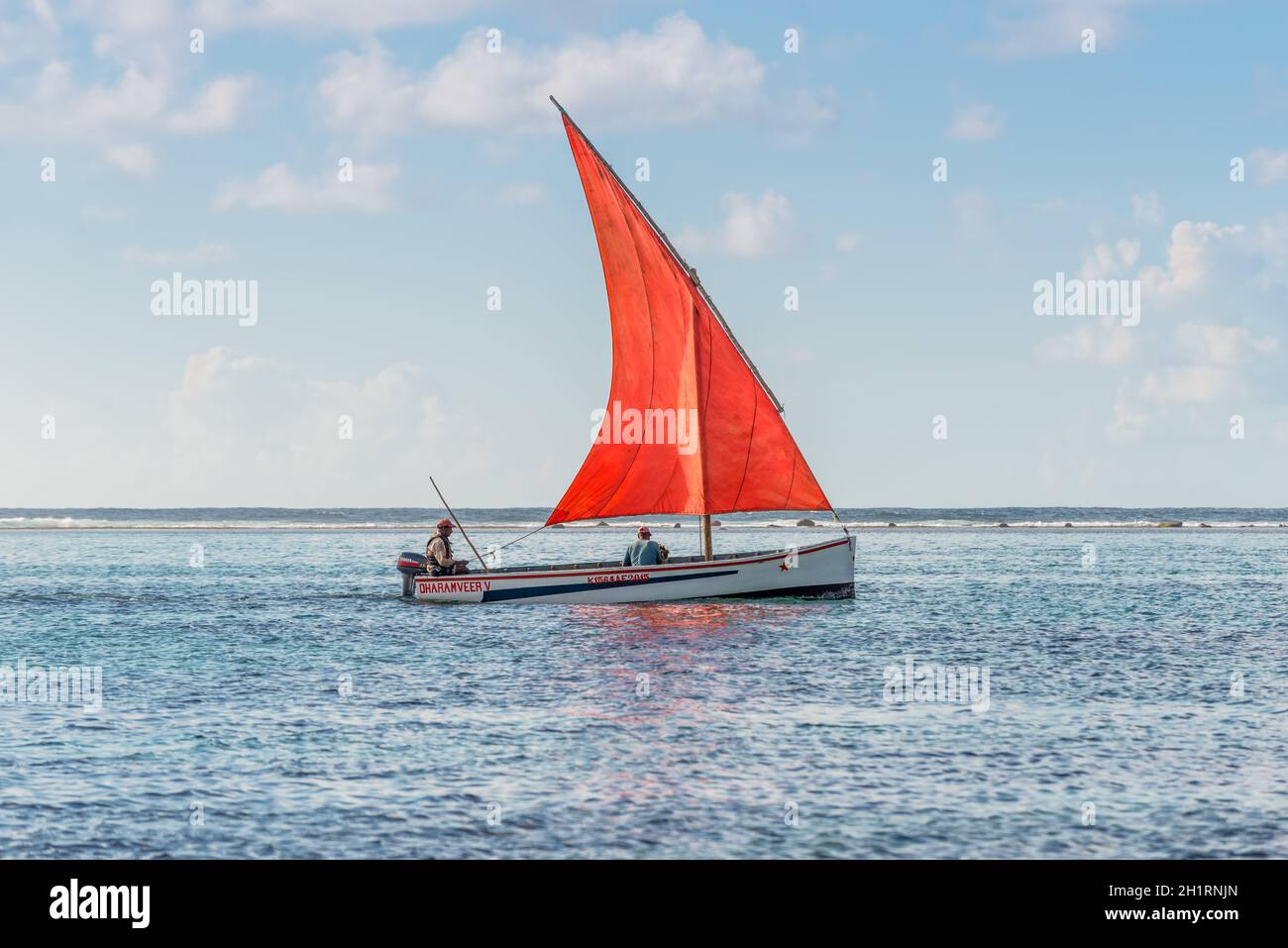Blue Bay, Mauritius - December 28, 2015: The romantic boat with scarlet sail in Indian Ocean - Beautiful sea scene in Blue Bay, Mauritius. Stock Photo