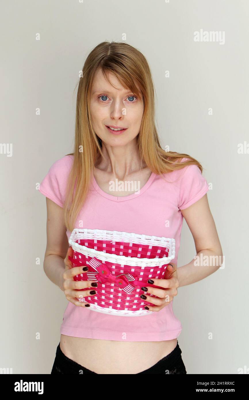 Young teenage girl in pink shirt holding empty basket with decorative bow  Stock Photo - Alamy