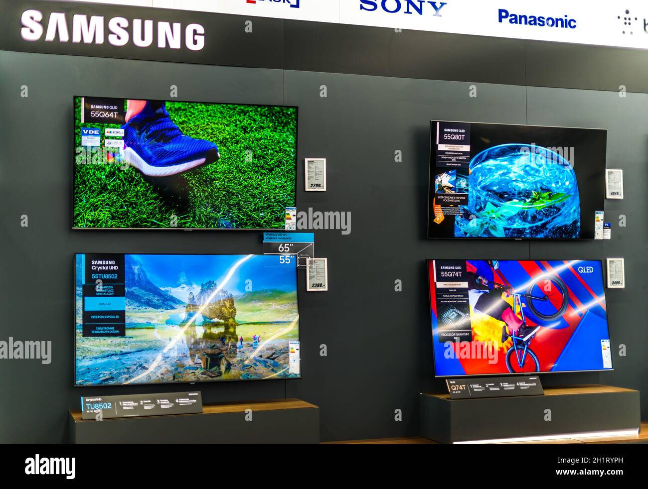POZNAN, POL - FEB 24, 2021: Modern flat-screen TV sets by Samsung put up for sale in an electronics store Stock Photo