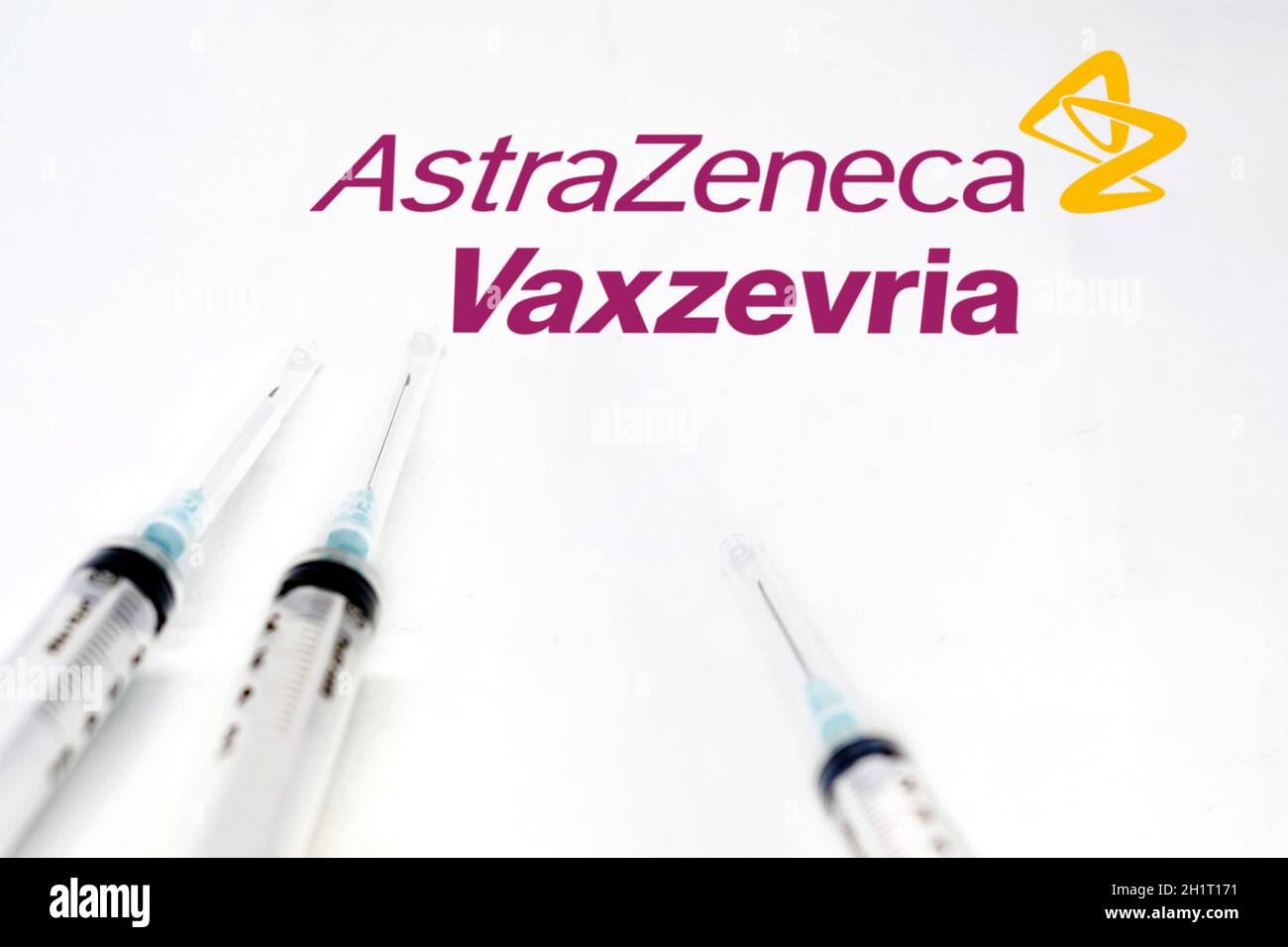 Cambridge, England, UK, march 30 2021: Three syringes next to the Vaxzevria and AstraZeneca logo isolated on a white background. Health and prevention Stock Photo