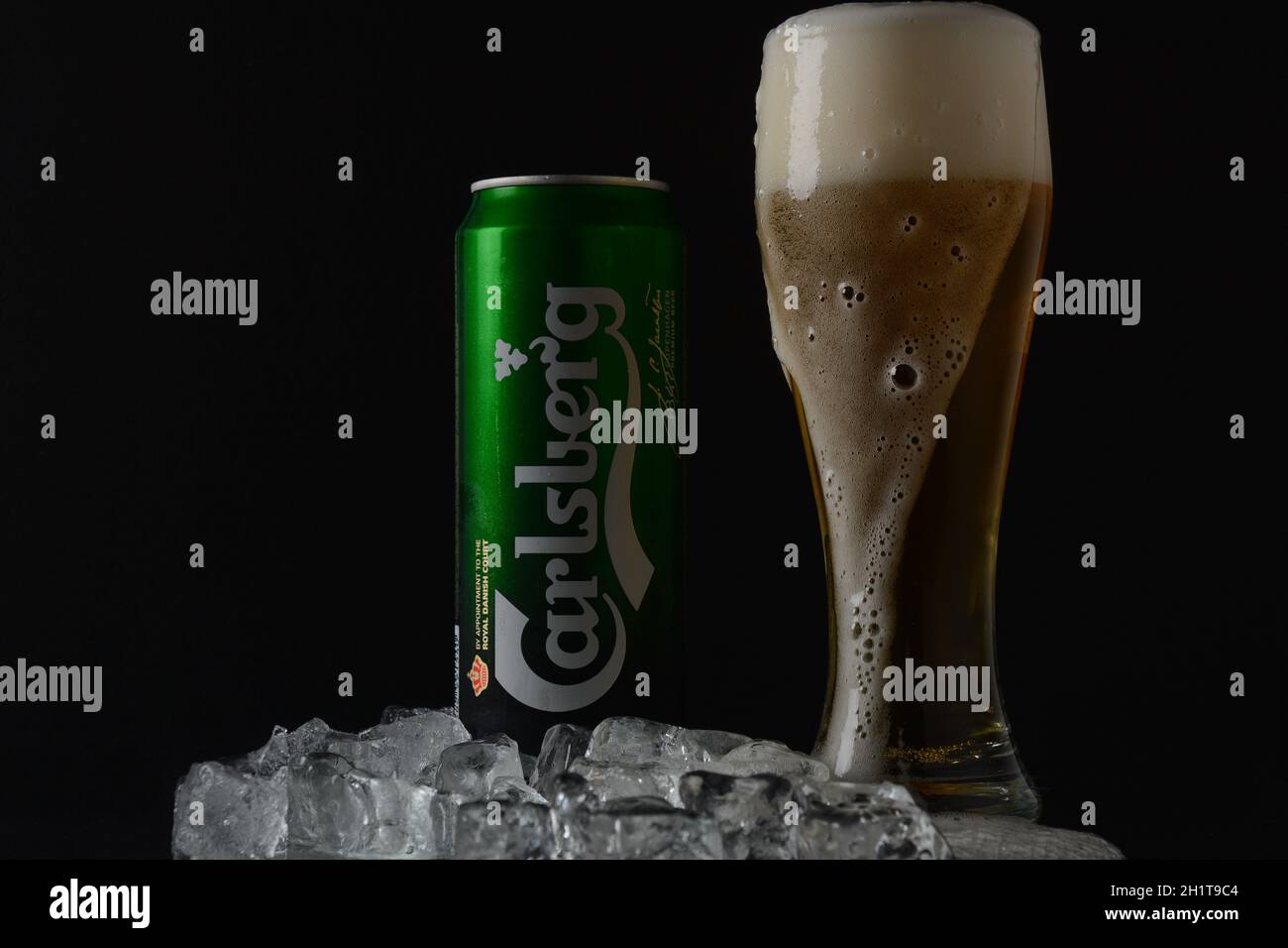NETANYA,ISRAEL- June 29, 2020: Cold glass and aluminium can of Carlsberg beer black background. Danish brewing company founded in 1847. Stock Photo