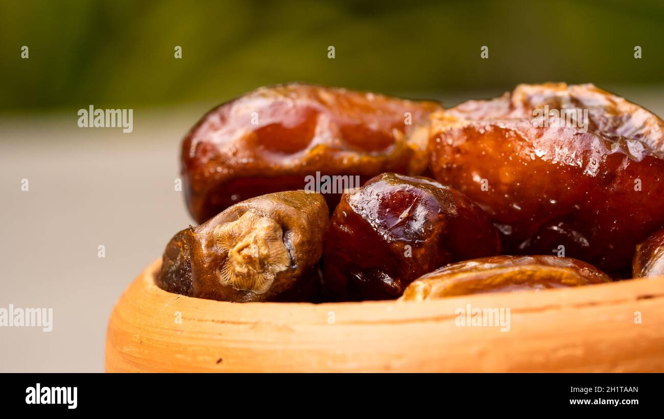 Dates in clay bowl on background. dried dates fruit. Stock Photo