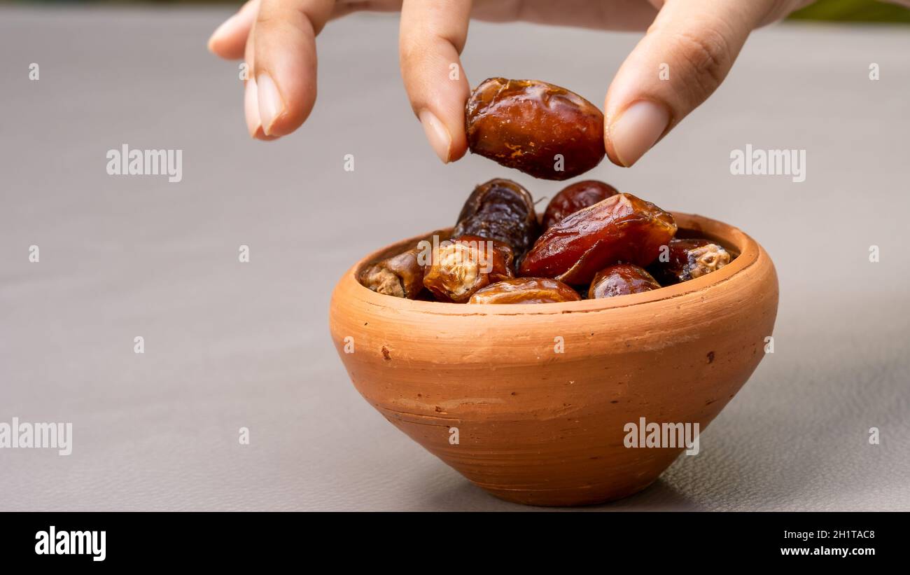 Dates in clay bowl on background. dried dates fruit. Stock Photo