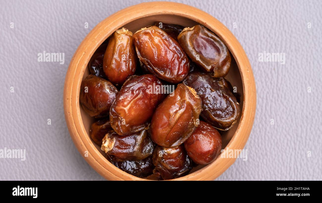 Dates in clay bowl on background. dried dates fruit. Stock Photo